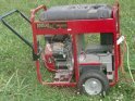 Red portable generator standing on grass